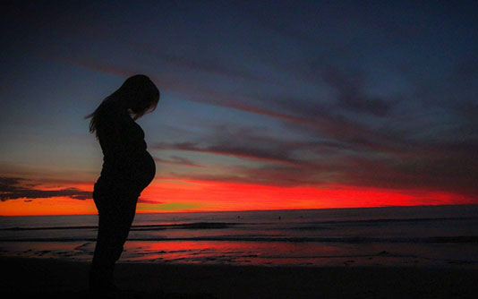Pregnant woman in the sunset